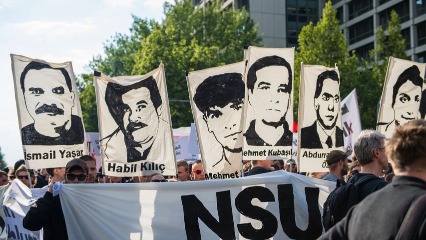 Demonstranten halten vor der Urteilsverkündung im NSU-Prozess gegen Beate Zschäpe und andere im Jahr 2018 in München Bilder der vom NSU Ermordeten hoch.

