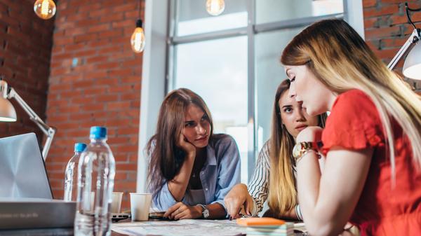 Group of women working sitting at desk in office