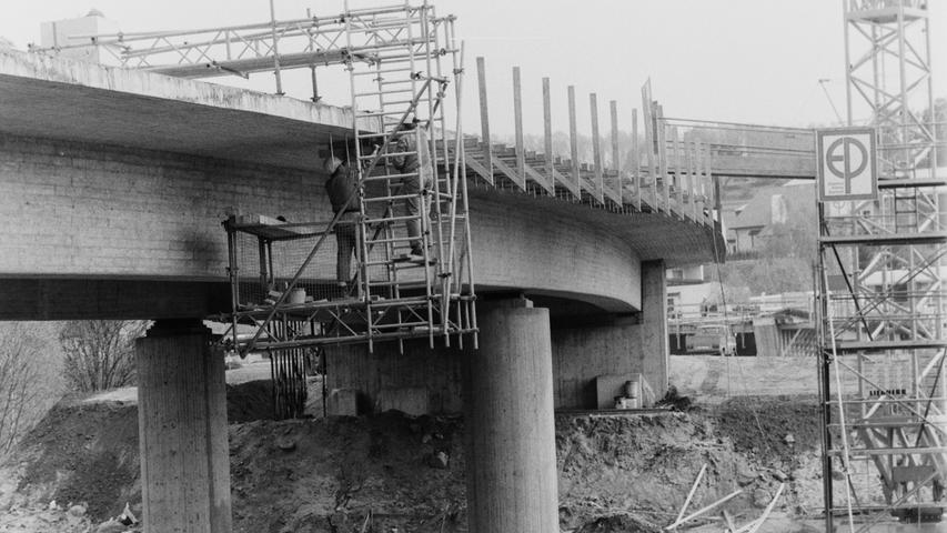 Mit Hochdruck wurde 1994 am Bau der Guyancourt-Brücke gearbeitet. Die Realisierung der neuen Verbindung von der Bundesstraße 2 hinüber zum Pegnitzer Industriegebiet "Kleiner Johannes" verlief völlig im Zeitplan, wie der erfahrene Brückenspezialist Harald Adelhardt von der Firma Pöhner erläuterte. Während die ersten Teerarbeiten durchgeführt wurden, begann zwischen den beiden Brückenteilen die Schüttung des 80 Meter langen Erddamms mit Erdaushub von der Baustelle der neuen KSB-Halle W12, der in der Nachbarschaft zwischengelagert war. Die Brücke war für den stark angewachsenen Lastverkehr zur KSB, zur Abfallfirma NBS oder zu Baier + Köppel nötig geworden, um die bis dato einzige Verbindung über die Bahnhofstraße zu entlasten.