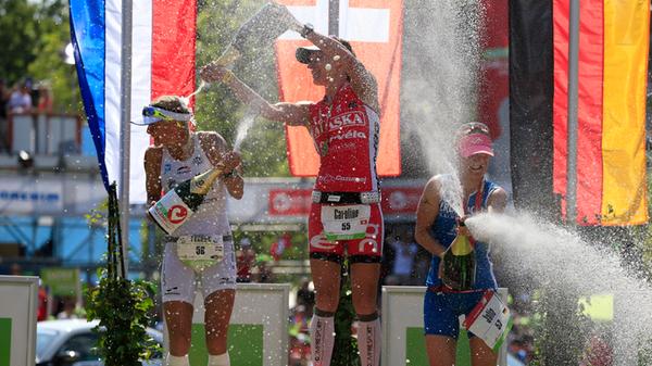 Caroline Steffen (SUI, in der Bildmitte) feiert ihren Sieg 2013 in 8:45:04 mit einer Sektdusche.