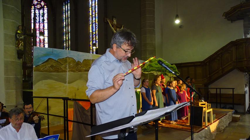 Volker Gloßner dirigierte sein Orchester und die Kinder in der vollbesetzten Kirche. Eine Herkulesaufgabe.