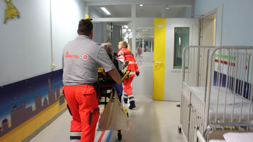 Ankunft in der Klinik Hallerwiese: Die Sanitäter schieben den Patienten auf der Trage in die Klinik zur Anmeldung.