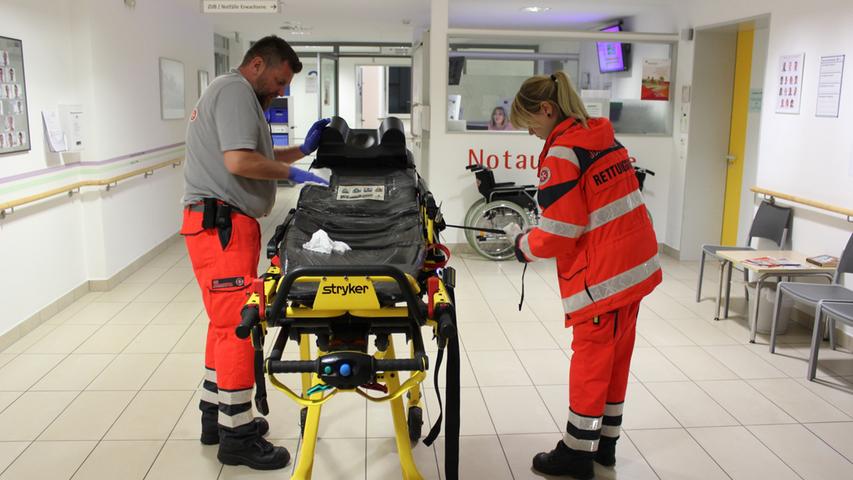 Der Patient ist in der Klinik aufgenommen. Jetzt reinigen die Sanitäter Anna Schneider und Markus Hitz die Trage, ehe diese wieder in den Rettungswagen geschoben wird.