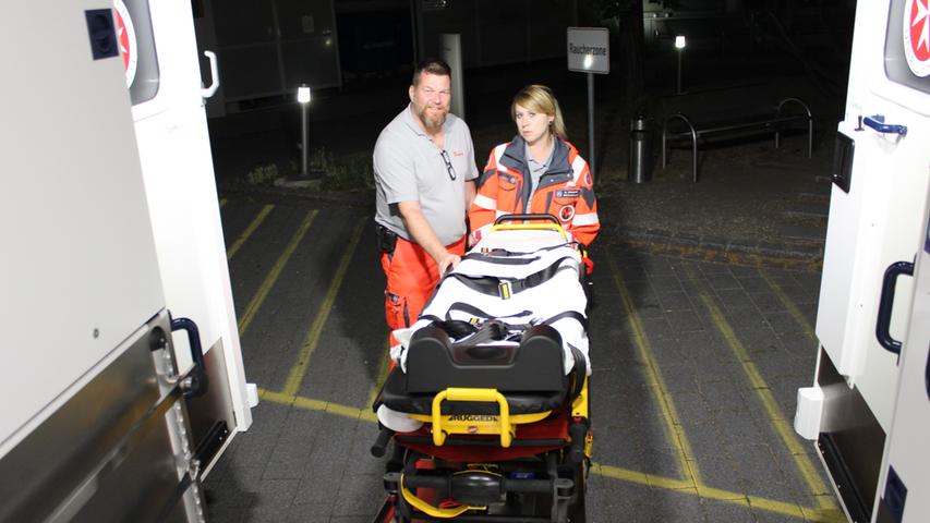 Markus Hitz und Anna Schneider schieben die Trage wieder zurück in den Rettungswagen.