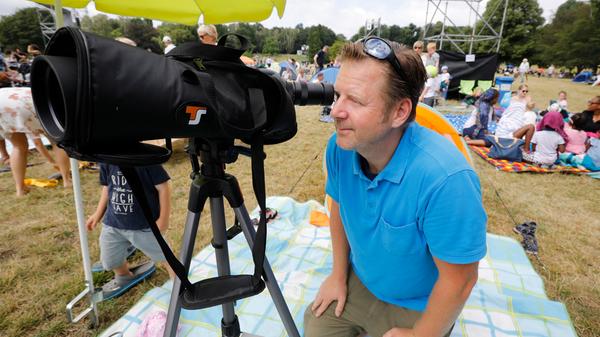 Die Ehefrau im Visier: Stephan Clemens schaut durch das Fernglas, mit dem er Ehefrau Nicole Spuhler-Clemens mit 60facher Vergrößerung sehen kann. Sie sitzt auf der Bühne und spielt Klarinette.