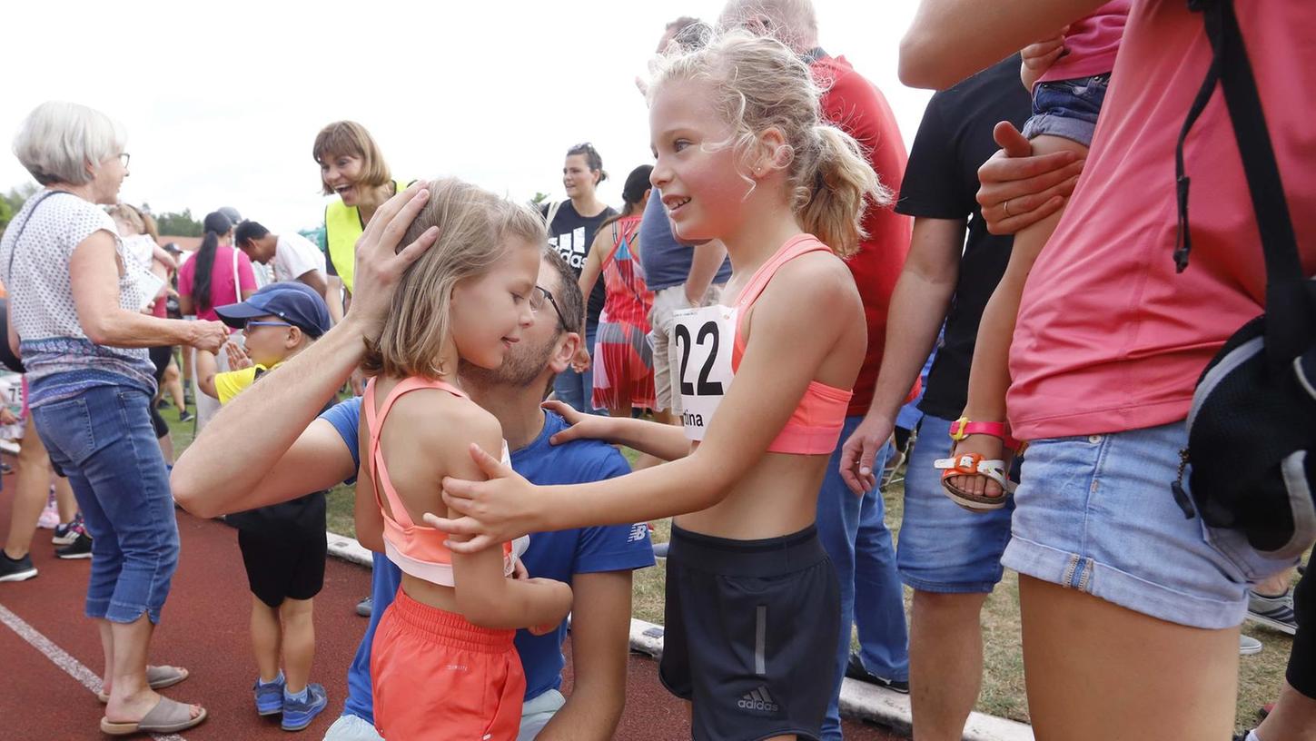 Glückwunsch nach dem Zieleinlauf: Der Papa und die große Schwester gratulieren diesem Mädchen nach ihrem vermutlich ersten sportlichen Wettkampf.
