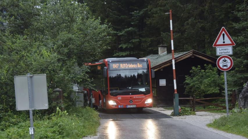 Weiter geht es zur Kallbrunnalm. Der Alm-Erlebnisbus überquert die deutsch-österreichische Grenze. Um den Schlagbaum zu öffnen, steigt der Busfahrer aus.