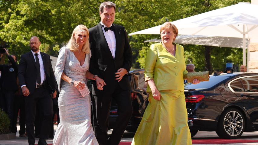 Sie darf natürlich nicht fehlen - Kanzlerin Angela Merkel (rechts) erscheint dieses Jahr in einer grünen Kombination. Der Bayerischen Ministerpräsidenten Markus Söder (CSU) und seine Frau Karin begleiten sie.