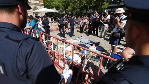 Polizisten umzingeln Aktivisten, die sich vor dem Festspielhaus in Bayreuth auf den Boden gelegt haben. Sie demonstrieren für mehr Klima- und Artenschutz und gehören der Bewegung "extinction rebellion" an.