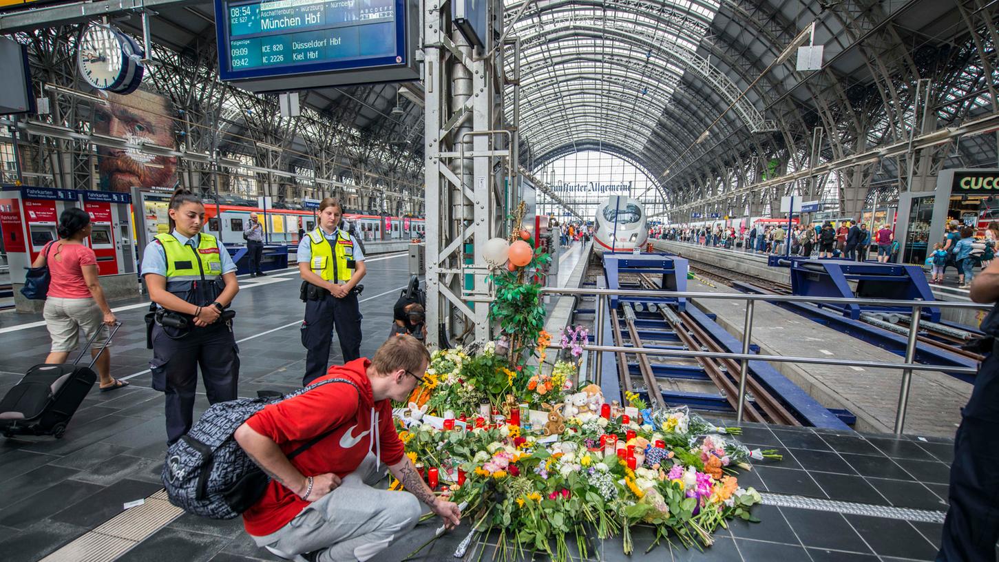 Passanten und Reisende haben am Dienstag am Hauptbahnhof in Frankfurt am Main Blumen und Stofftiere zum Gedenken an den Jungen abgelegt, der am Montag zusammen mit seiner Mutter vor einen einfahrenden ICE gestoßen worden war.
