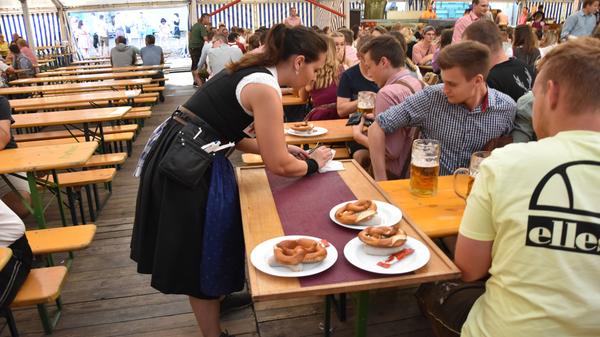 Die Kellner haben in den ersten Minuten gut zu tun, um die zahlreichen Gäste mit Speis und Trank zu versorgen. Sie tragen den ganzen Vormittag schwere Tabletts mit Speisen und bis zu vierzehn Bierkrüge auf einmal.