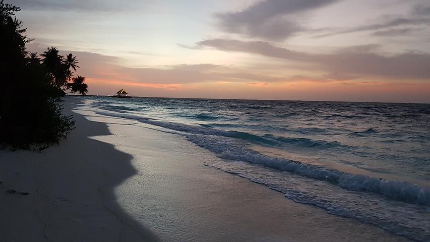 Eine kitschig-wundervolle Oase für Verliebte - wie aus dem Katalog: Besonders die Sonnenuntergänge wie hier im Raa-Atoll sorgen für die Extra-Portion an großen Gefühlen.