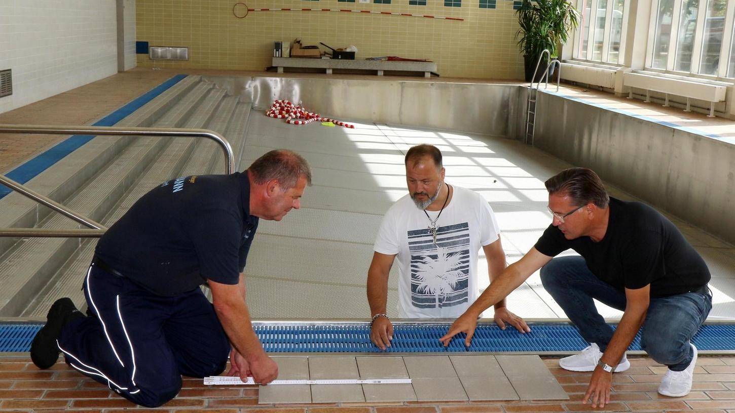 Erst im August 2019 wurde das Becken im Adelsdorfer Hallenbad wieder auf Vordermann gebracht (von links): Fliesenlegermeister Herbert Heumann, Hausmeister Marco Boco, Bürgermeister Karsten Fischkal.