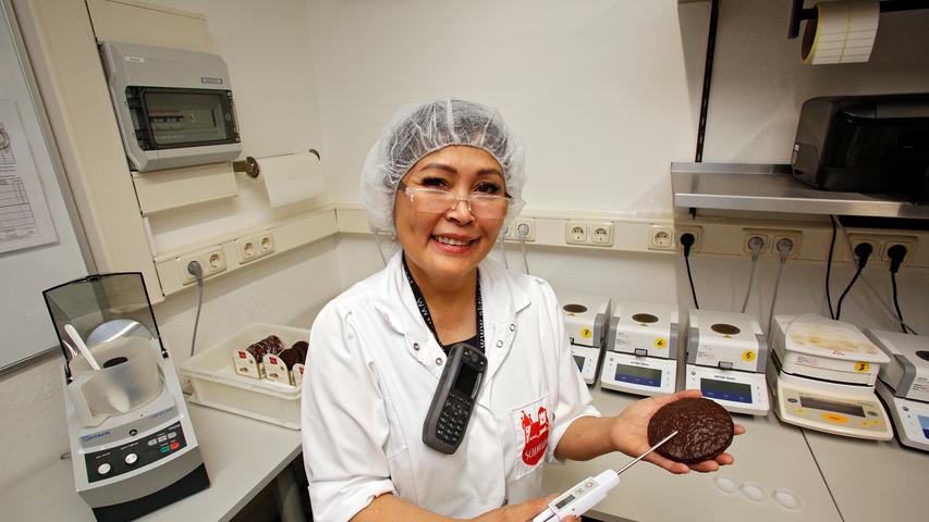 Josen Thomaier steckt in ihrem kleinen Labor eine lange Nadel in einen fertigen Lebkuchen.