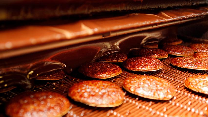 Im Sekundentakt verschwinden Oblatenlebkuchen unter dem Schokoladenschleier. Am Ende der Nacht liegen 20 Tonnen Süßes im Lager.
