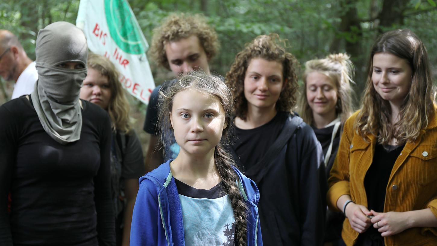 Die Klimaschutzaktivistin Greta Thunberg steht mit anderen Aktivisten im Hambacher Forst. Die Schwedin war für den Besuch des Braunkohletagebaus im Forst angereist.