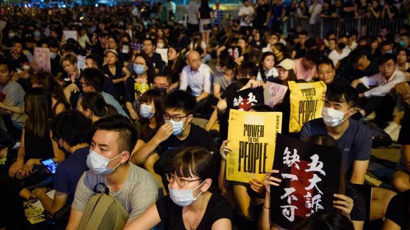 Mit Regenschirmen haben sich Hongkonger versammelt, um an einer von Lehrern organisiserten Demonstration teilzunehmen.