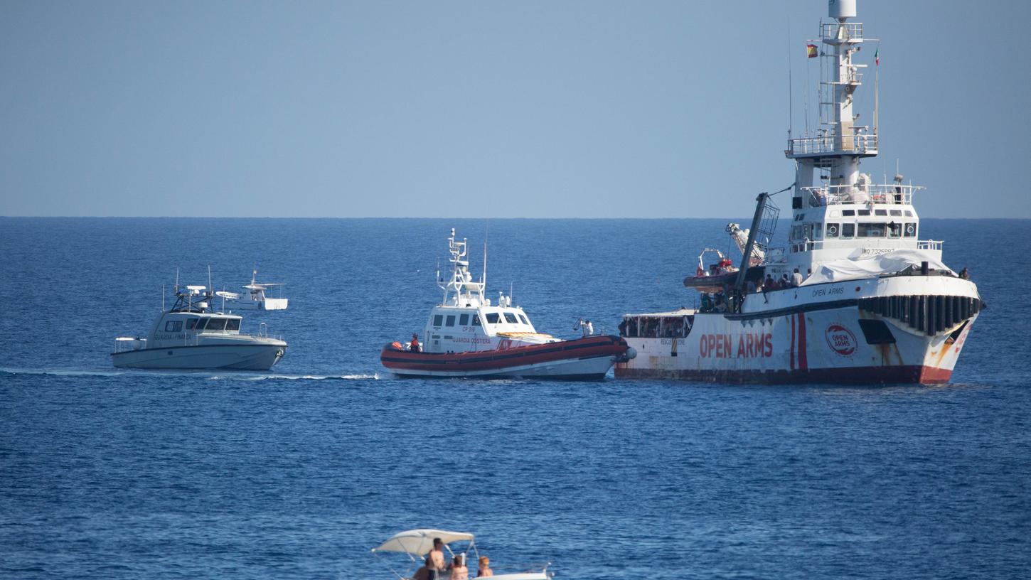 Ein Schiff der Guardia di Financa und der Guardia Costeria, der italienischen Küstenwache, legen an das Schiff "Open Arms" der Hilfsorganisation Proactiva Open Arms an.