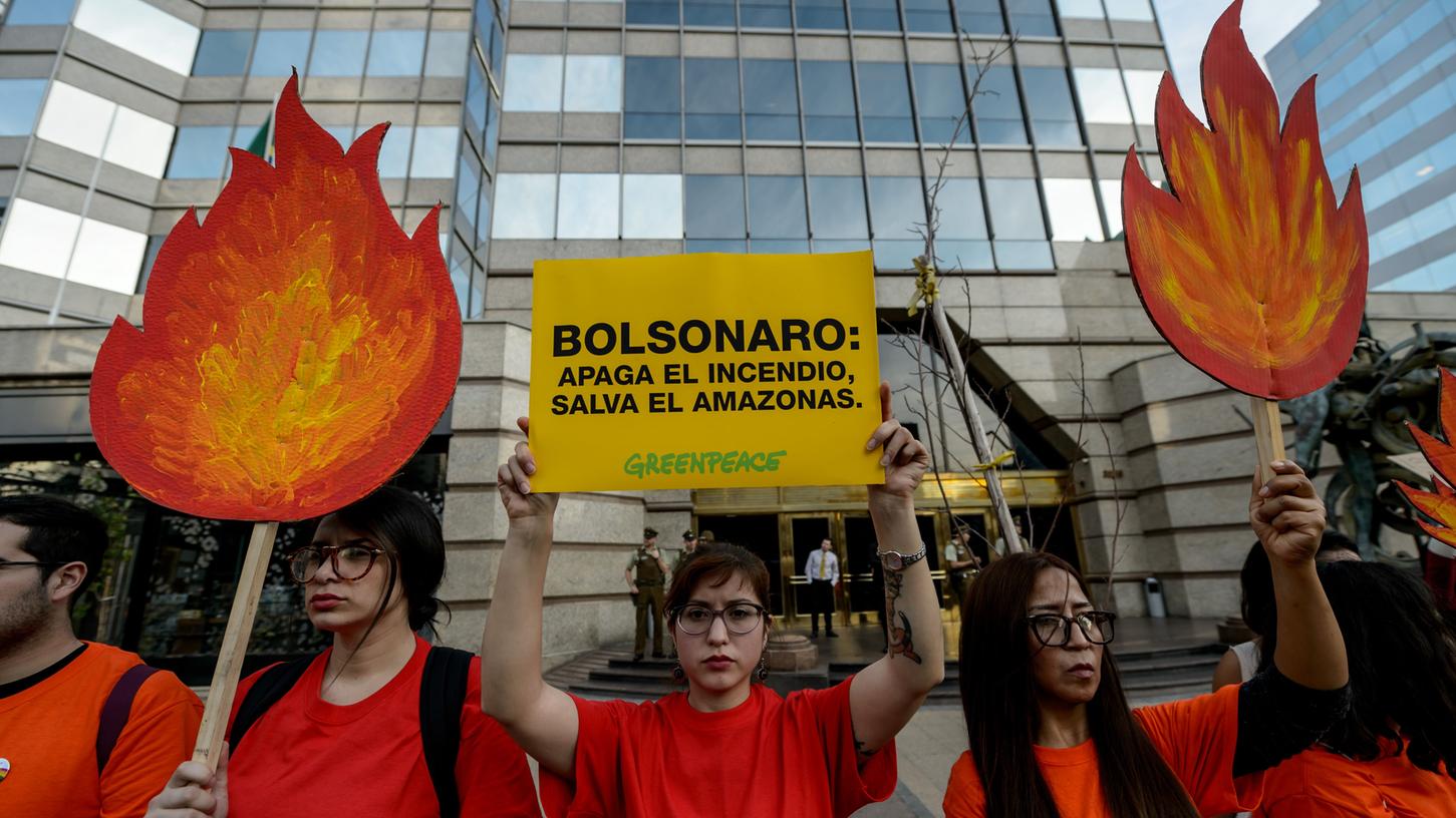 Aktivisten demonstieren in Santiago gegen den brasilianischen Präsidenten Bolsonaro.