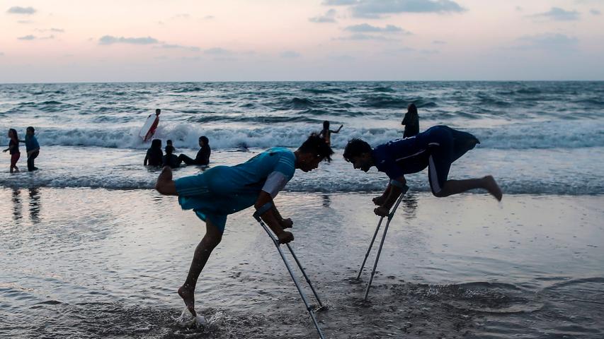 Angespannt bleibt die Lage auch zwischen Israel und den Palästinensern. Und auch hier fordert der Konflikt immer wieder neue Opfer. Das Foto zeigt eine Szene vom Strand in Gaza-Stadt, in der zwei junge Männer spielen, die bei Zusammenstößen an der Grenze zu Israel ihre Beine verloren haben.