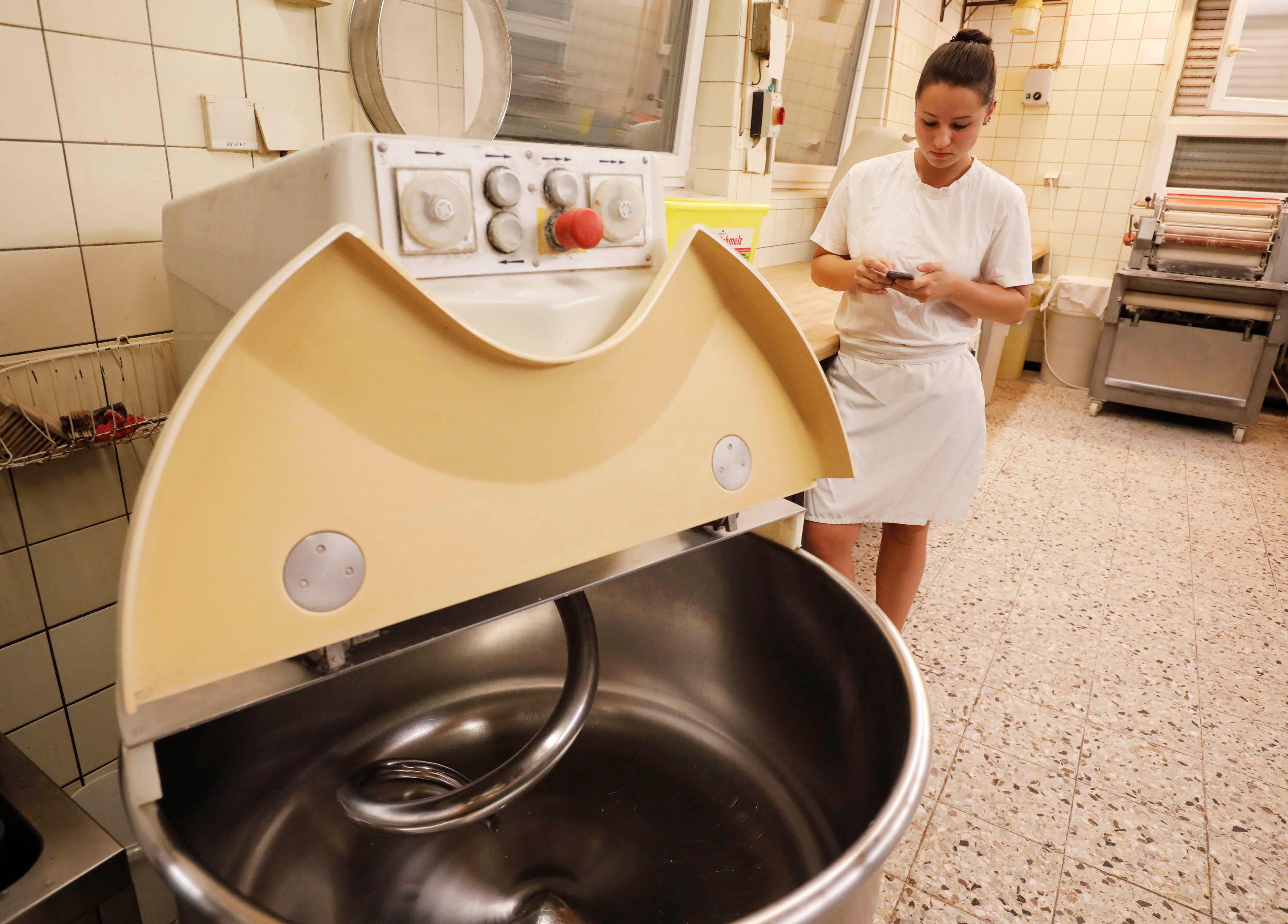 Mit dem Taschenrechner kontrolliert Bäckergesellin Katharina Zindel genau nach, wie viel von welcher Zutat in den Brotteig muss.