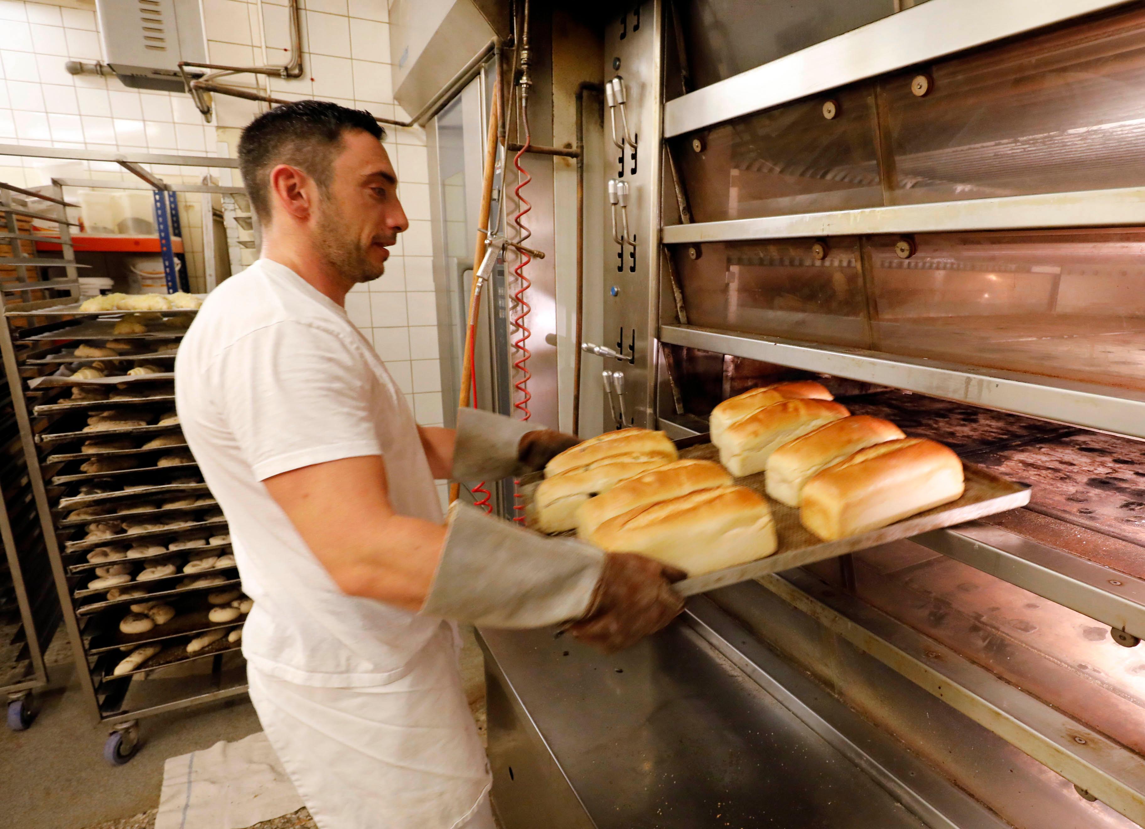 Fertig: Bäcker Markus Döllner zieht die frisch gebackenen Brote aus dem Ofen.