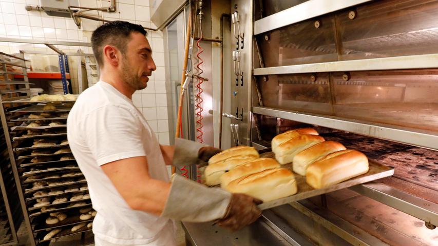 Fertig: Bäcker Markus Döllner zieht die frisch gebackenen Brote aus dem Ofen.