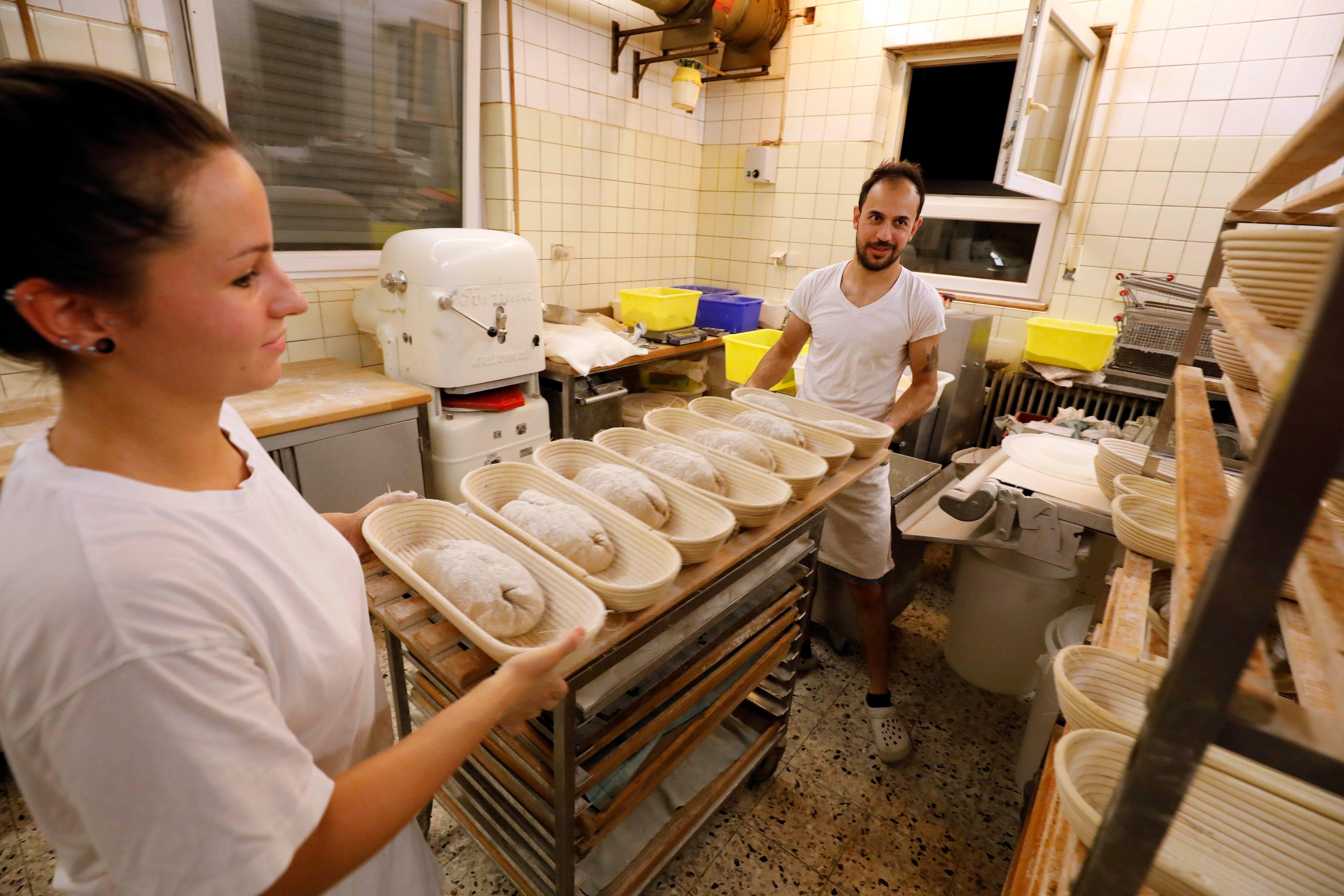 Gemeinsam stellen Gesellin Katharina Zindel und Azubi Naji Dakhil Naser die fertigen Teige an die Seite, bevor sie die nächsten vorbereiten.