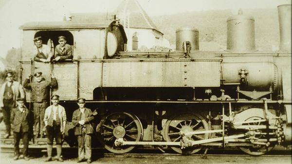 Eine Dampflok der Baureihe 89.8 (Baujahr 1921-23) samt Mannschaft im Treuchtlinger Bahnhof. Im Hintergrund ist das Dach der Vierzehn-Nothelfer-Kapelle zu sehen. Die letzte vorreformatorische Wallfahrtskirche der Region wurde 1934 für die Erweiterung des Bahnhofsgeländes abgerissen.