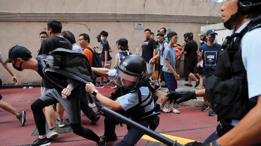Unversöhnlich: Polizeibeamte nehmen vor dem Amoy Plaza Einkaufszentrum in Hongkong einen jungen Mann nach Kämpfen zwischen Pro-China-Anhängern und Anti-Regierungs-Protestierenden fest. Die Zusammenstöße ereigneten sich nach mehreren Nächten friedlicher Kundgebungen in Einkaufszentren, bei denen Protestierende demokratische Reformen forderten.