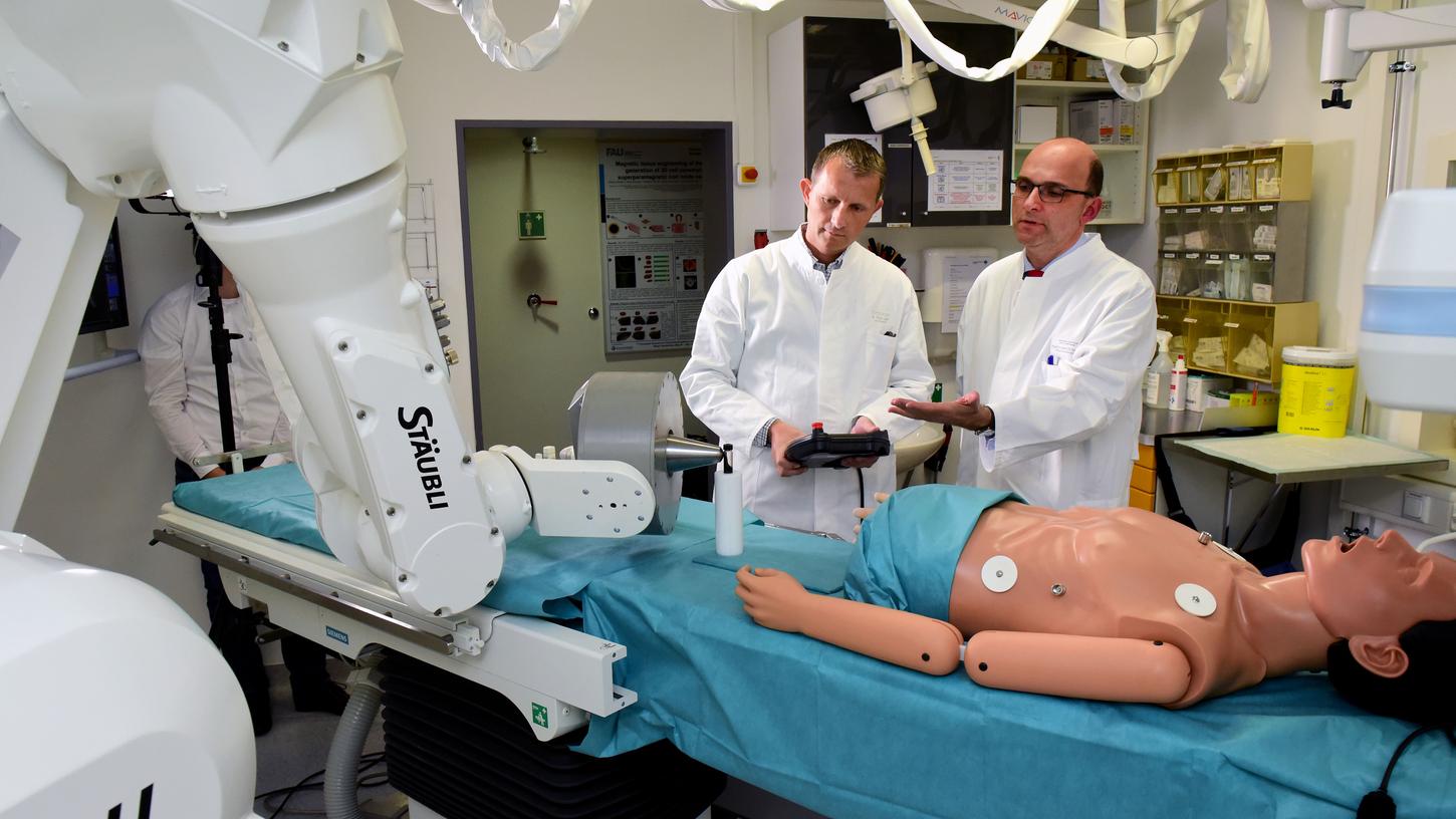 So sieht der neue Roboter aus, noch darf er aber nicht bei Patienten eingesetzt werden. Seon-Leiter Professor Christoph Alexiuo (rechts im Bild) und sein Stellvertreter, Dr. Stefan Lyer, zeigen ihn trotzdem schon einmal.