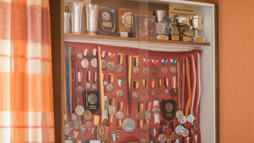 Dort zeugt ein Glaskasten voller Medaillen von seinen sportlichen Leistungen.