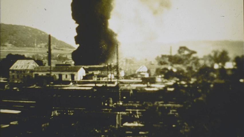 Eine schwarze Rauchsäule steht nach einem Bombentreffer im Zweiten Weltkrieg über dem Treuchtlinger Bahnhof. Vermutlich ist das getroffene Areal mit dem Schornstein das ehemaliger Gaswerk.