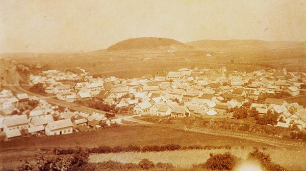 Im Herbst 1869 fuhr der erste Zug von Treuchtlingen über Weißenburg nach Pleinfeld. Das Bild zeigt den Verlauf der Trasse durch das damals noch winzige Treuchtlingen vom Perlachberg aus aufgenommen. Gut erkennbar sind die drei beschrankten Bahnübergänge (links, hell) - im Vordergrund unweit des heutigen Friedhofs und in der Mitte auf Höhe der heutigen Oettinger Straße. Unterführungen gab es erst später. Im Hintergrund ist der Nagelberg zu sehen und davor schwach erkennbar Schloss und Rathaus.