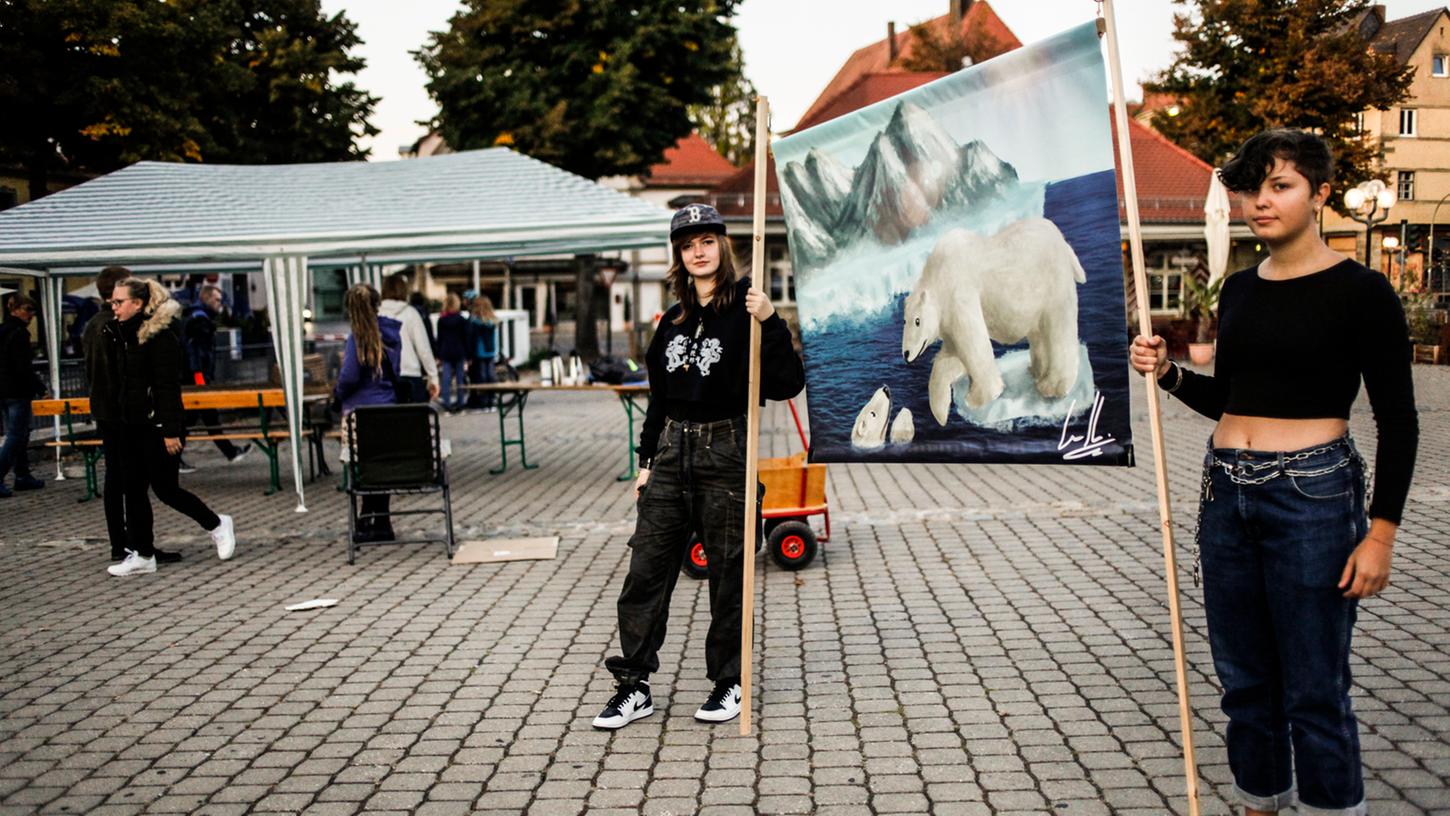 Lena Kiermaier (links) und Pauline Och (rechts) bei der Mahnwache auf dem Paradeplatz in Forchheim. Mit Kreide wollen sie Sprüche, Erdkugeln und Pflanzen oder andere Klimasymbole auf den Boden malen.