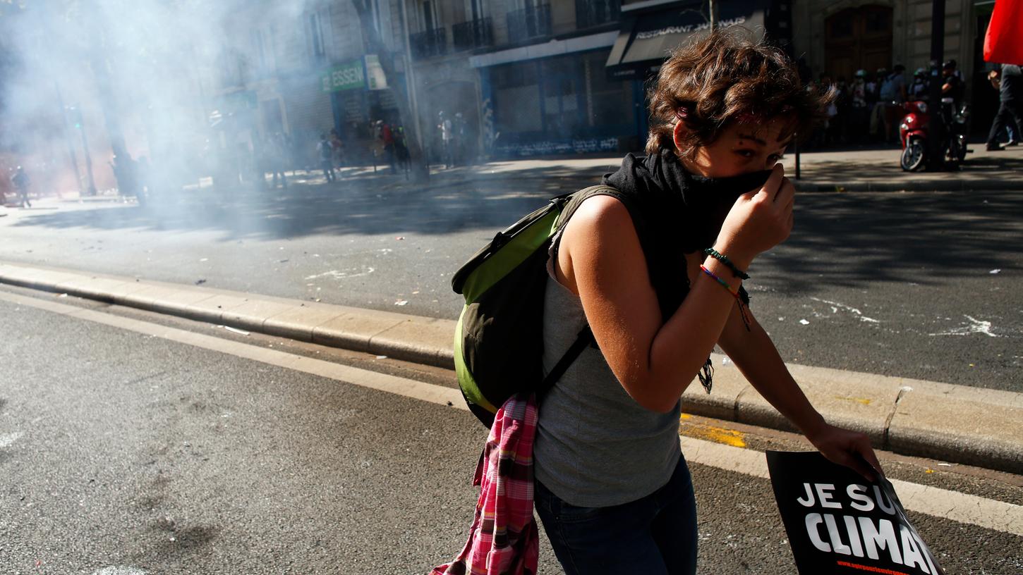 Eine Demonstrantin hält sich einen Schal vor den Mund, um sich vor Tränengas zu schützen.