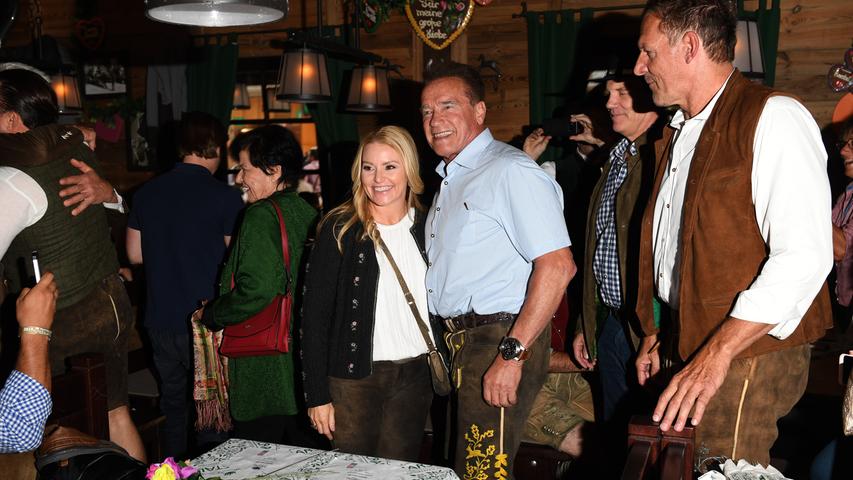 Heather Milligan sowie die Schauspieler Arnold Schwarzenegger und Ralf Möller lassen sich in der Promibox des Marstall Festzelts ablichten.