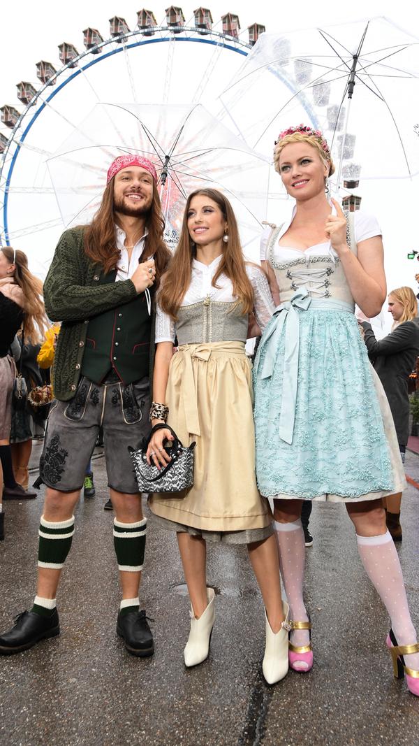 Entertainer Riccardo Simonetti, Moderatorin Cathy Hummels und Model Franziska Knuppe trotzen dem grauen Himmel beim "Wiesn-Bummel".