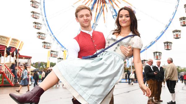 Schauspieler Timur Bartels trägt seine Freundin Michelle auf Händen über die Wiesn.