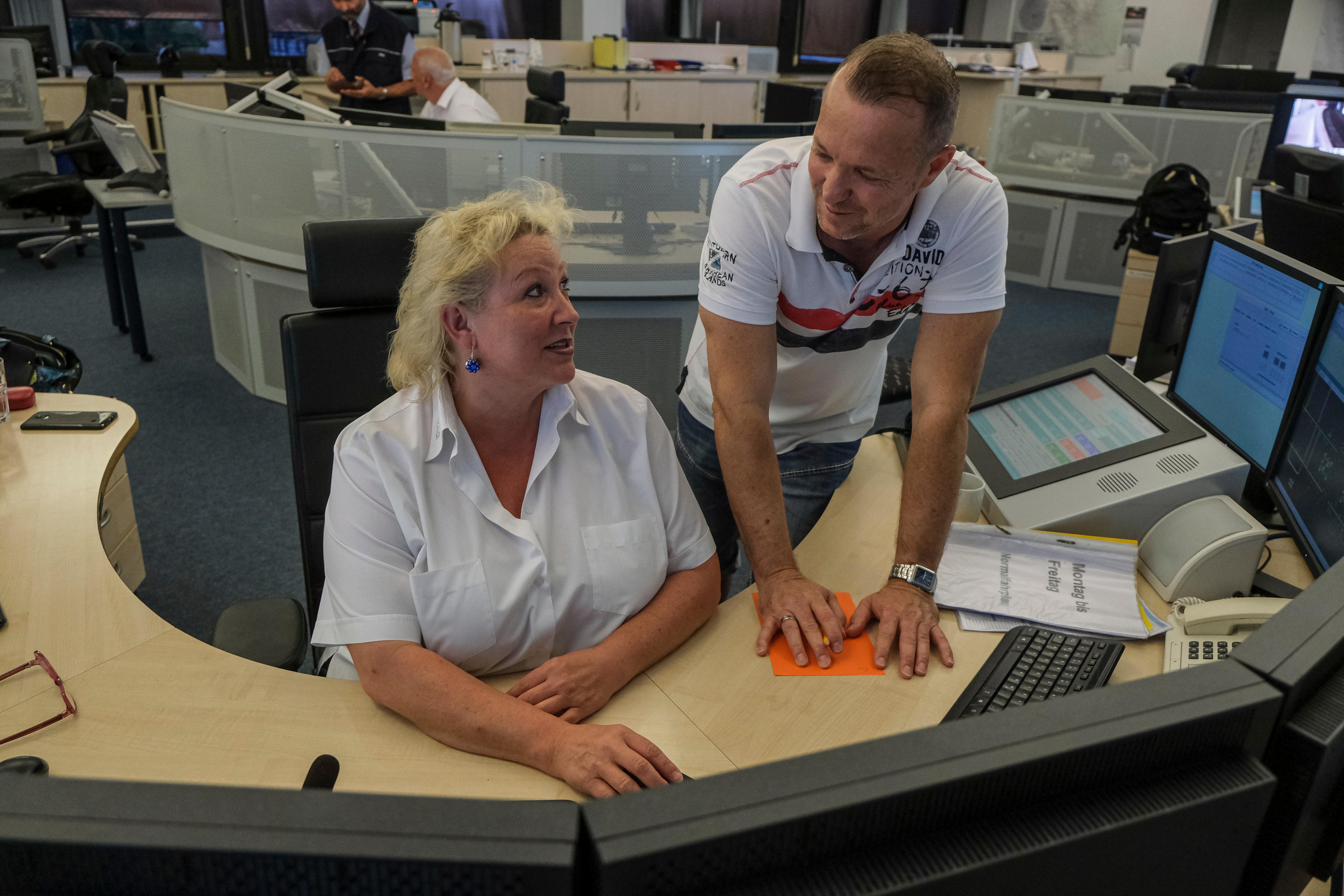 In der Leitstelle erkundigt sich Einsatzkoordinator Christian Hannweber bei einer Kollegin nach aktuellen Vorfällen. In der Leitstelle gehen nachts auch die Anrufe über das Servicetelelfon ein.