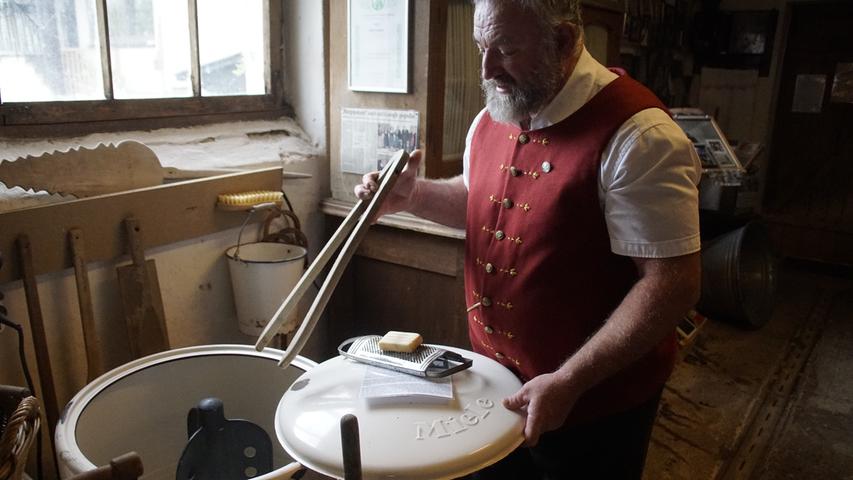 Robert Bogner zeigt, wie eine alte, elektrische Waschmaschine, die vom Hof stammt, bedient wurde.