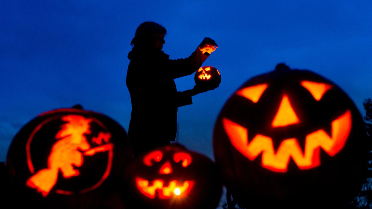 Kürbis-Gesichter flackern in der Dunkelheit: Ein alter Brauch zum Halloween-Fest.
