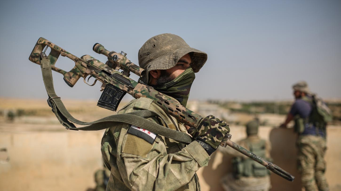 Ein Scharfschütze der Syrischen Nationalarmee trägt eine Waffe auf der Schulter. Seit mehreren Tagen toben an der Grenze zwischen der Türkei und Syrien Kämpfe zwischen der türkischen Armee und Kurdenmilizen. Ein Scharfschütze der Syrischen Nationalarmee trägt eine Waffe auf der Schulter. Seit mehreren Tagen toben an der Grenze zwischen der Türkei und Syrien Kämpfe zwischen der türkischen Armee und Kurdenmilizen.