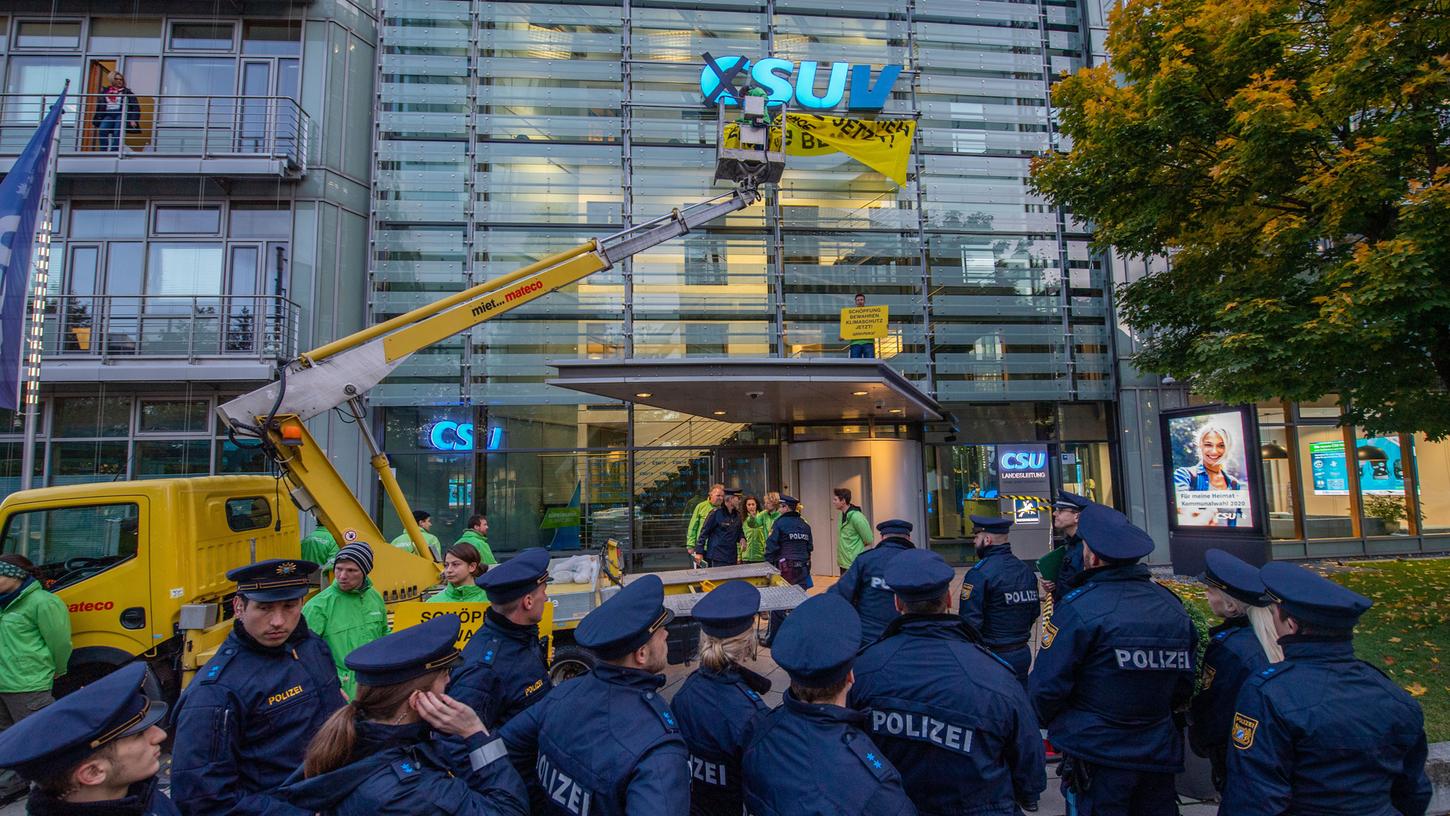 Mit einem Hubwagen änderten Aktivisten der Organisation "Greenpeace" das Parteilogo an der CSU-Zentrale in München.