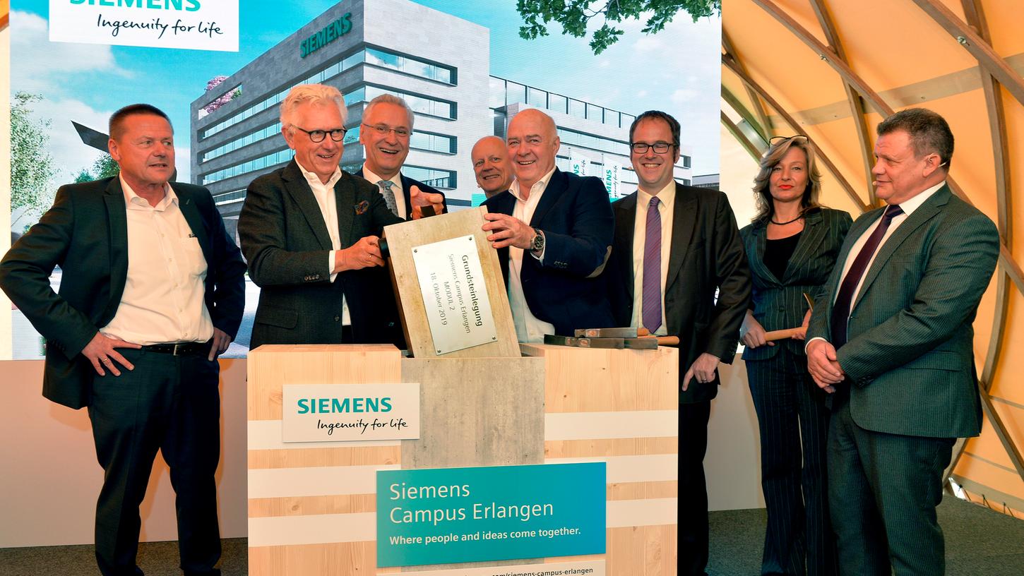 Zur Grundsteinlegung fanden sich neben Siemens-Finanzchef Ralf P. Thomas (4.v.li) und CEO Real Estate Zsolt Sluitner ( re) auch Innenminister Joachim Herrmann (3.v.li) und OB Florian Janik (6.v.li) ein. Dazu gesellten sich Architekt Jürgen Engel (2.v.li), Bauunternehmer Kurt Zech ( 5.v.li) und die Siemens Betriebsräte Saskia Krausser (2.v.re) und Manfred Bäreis (li).