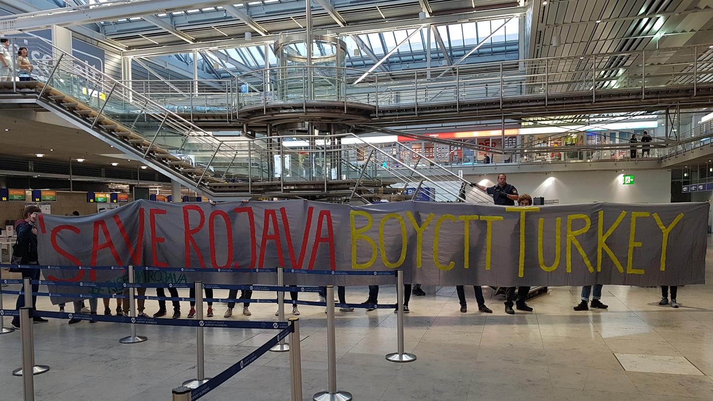 Aus Protest gegen den Militäreinsatz in Nordsyrien haben Aktivisten den Schalter von Turkish Airlines am Flughafen Nürnberg besetzt. Aus Protest gegen den Militäreinsatz in Nordsyrien haben Aktivisten den Schalter von Turkish Airlines am Flughafen Nürnberg besetzt.
