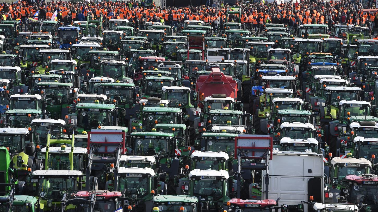 Landwirte aus Mecklenburg-Vorpommern stehen mit ihren Treckern bei einer Protestaktion gegen das Agrarpaket der Bundesregierung im Rostocker Stadthafen.