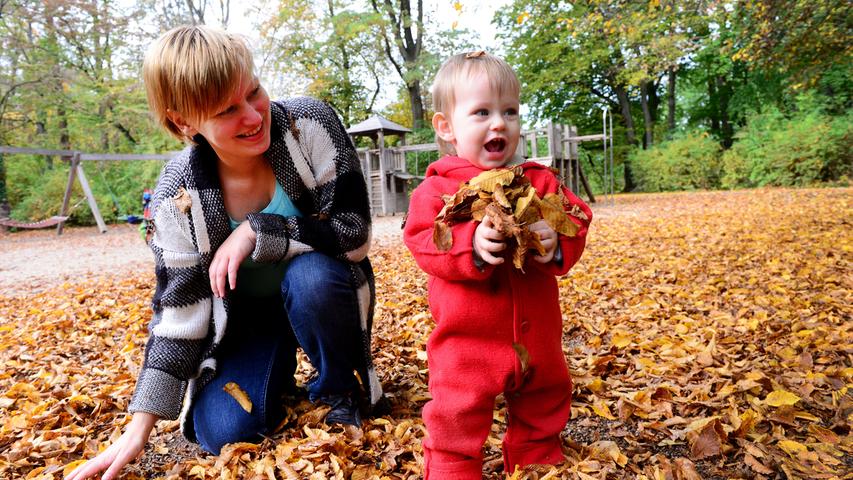Auf dem Spielplatz im Stadtpark haben Christine Kolibabka und ihr einjähriger Sohn Erik so richtig Spaß mit dem bunten Laub.