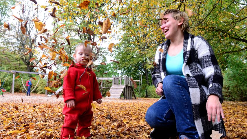 Auf dem Spielplatz im Stadtpark haben Christine Kolibabka und ihr einjähriger Sohn Erik so richtig Spaß mit dem bunten Laub.