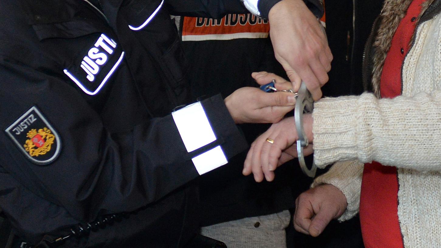 Einem Mitglied des Miri Clans werden im Prozess um unerlaubten Betäubungsmittelhandel im Saal des Landgerichts in Bremen von einem Justizbeamten die Handschellen abgenommen. (Archivbild)
